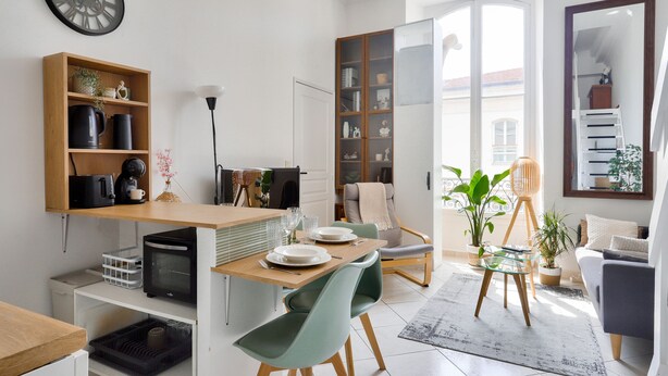 Una sala moderna con comedor, estantería y un ventanal grande.