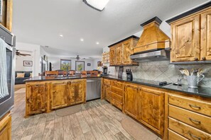 A kitchen with wooden cabinets, a central island, and a tiled backsplash.