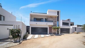 A modern two-story house with a garage, a small garden, and a paved driveway. - Stunning & Beautiful House With Private Pool (Cabo San Lucas)