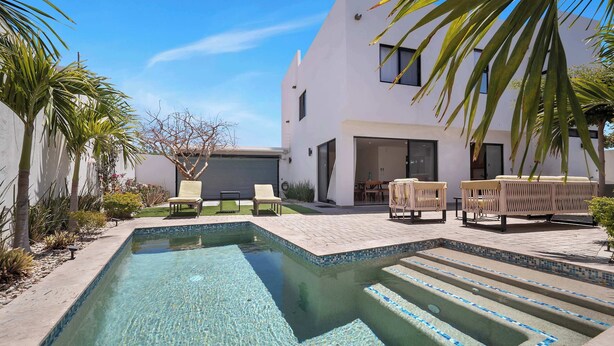 A modern pool with clear water, surrounded by a patio area with outdoor furniture. - Stunning & Beautiful House With Private Pool (Cabo San Lucas)