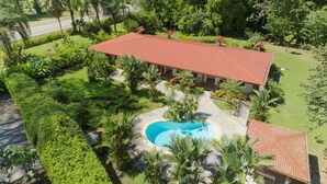A large building with a red roof, surrounded by well-maintained gardens and a swimming pool. - Stunning Suite 104 Walking Distance to the Beach (Savegre)