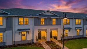 A multi-story residential building with a symmetrical facade, multiple windows, and a central entrance. - 5BR w Pool Grill Game Lounge Indoor Slide 16165 (Clermont)