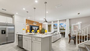 A modern kitchen with a central island, built-in appliances, and pendant lighting. - 5BR w Pool Grill Game Lounge Indoor Slide 16165 (Clermont)
