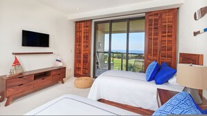 Ein Schlafzimmer mit einem Bett, einem Fernseher, einer Holzkommode und einem Balkon mit Blick.