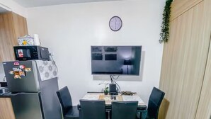 Cocina compacta con refrigerador, microondas y una mesa de comedor con sillas.