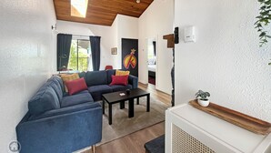 A modern living room with a sectional sofa, a coffee table, and a fireplace.