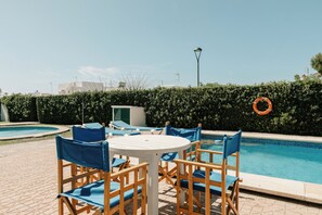 Ein Poolbereich mit Liegestühlen und einem Tisch.