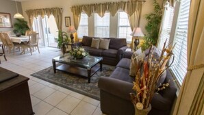 Sala de estar con sofá, mesa de centro y plantas decorativas.