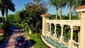 Una carretera que lleva al resort Emerald Island, con un coche estacionado al lado.