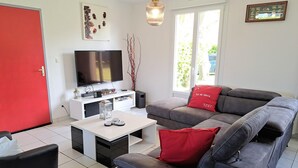 Ett vardagsrum med en TV, en soffa och ett soffbord.