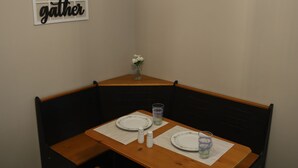A dining area with a wooden table, benches, and hanging light fixtures.
