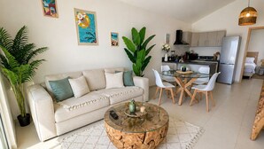 Ein Wohnzimmer mit einer Couch, Couchtisch und einem Essbereich mit Stühlen.