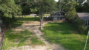 A residential area with a house, a fenced yard, and a small dock extending into a body of water. - Lakeview Lookout - Stunning Views! (Tool)