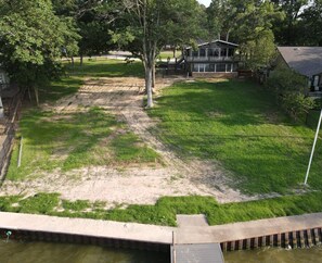 A residential area with a house, a fenced yard, and a small dock extending into a body of water. - Lakeview Lookout - Stunning Views! (Tool)