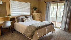 A bedroom with a bed, a desk, a chair, a dresser, and a window with blinds. - Lakeview Lookout - Stunning Views! (Tool)