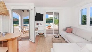 Una sala de estar moderna con un sofá, una mesa de comedor y un televisor.