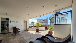 Une chambre d’hôtel moderne avec balcon, coin repas et vue sur la ville.