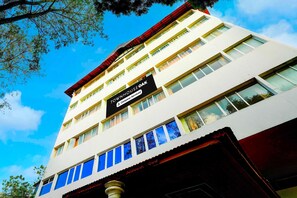 A multi-story building with a sign reading 'TOUR HOUSE OAK' and 'Company Serviced.' - Collection O Puthali Park (Mysore)