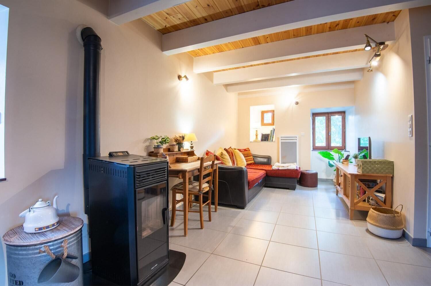Un salon avec une cheminée, un canapé, un coin repas et un espace cuisine.