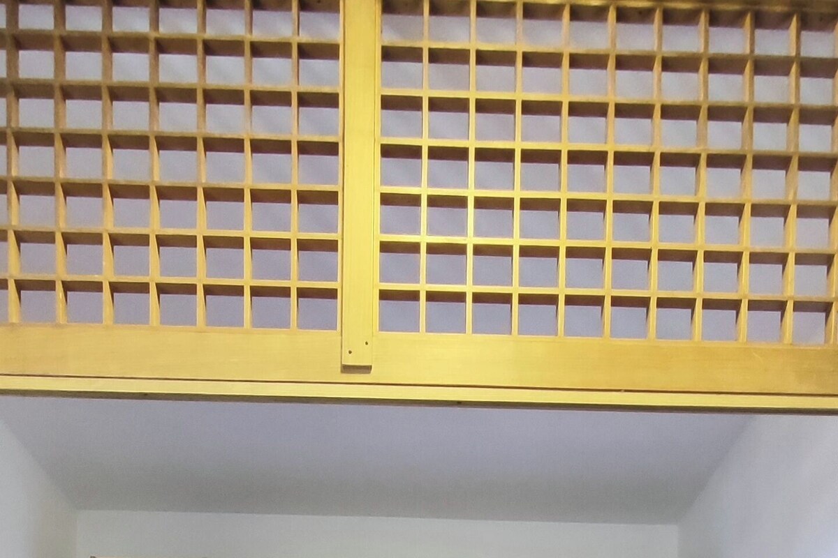 A room with a bed, red storage cabinets, and a tiled floor.