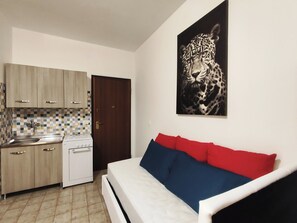 A kitchen with a white stove, a tiled backsplash, and wooden cabinets. - baia verde holiday (Baia Verde)