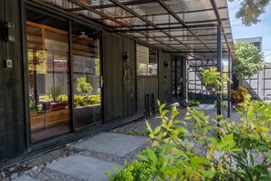 Un edificio moderno con amplios ventanales y un espacio exterior cubierto.