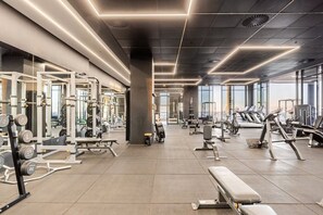 Ein modernes Fitnessstudio mit unterschiedlichen Trainingsgeräten, großen Fenstern und einer großzügigen Gestaltung.