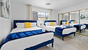 Habitación de hotel con dos camas, un espejo grande y vista a la ciudad.