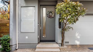 A modern house with a grey door, a small tree, and a wreath on the door. - Silverlake Sunset Treehouse Art-filled Escape w/ Jacuzzi + Sauna Avantstay (Los Angeles)