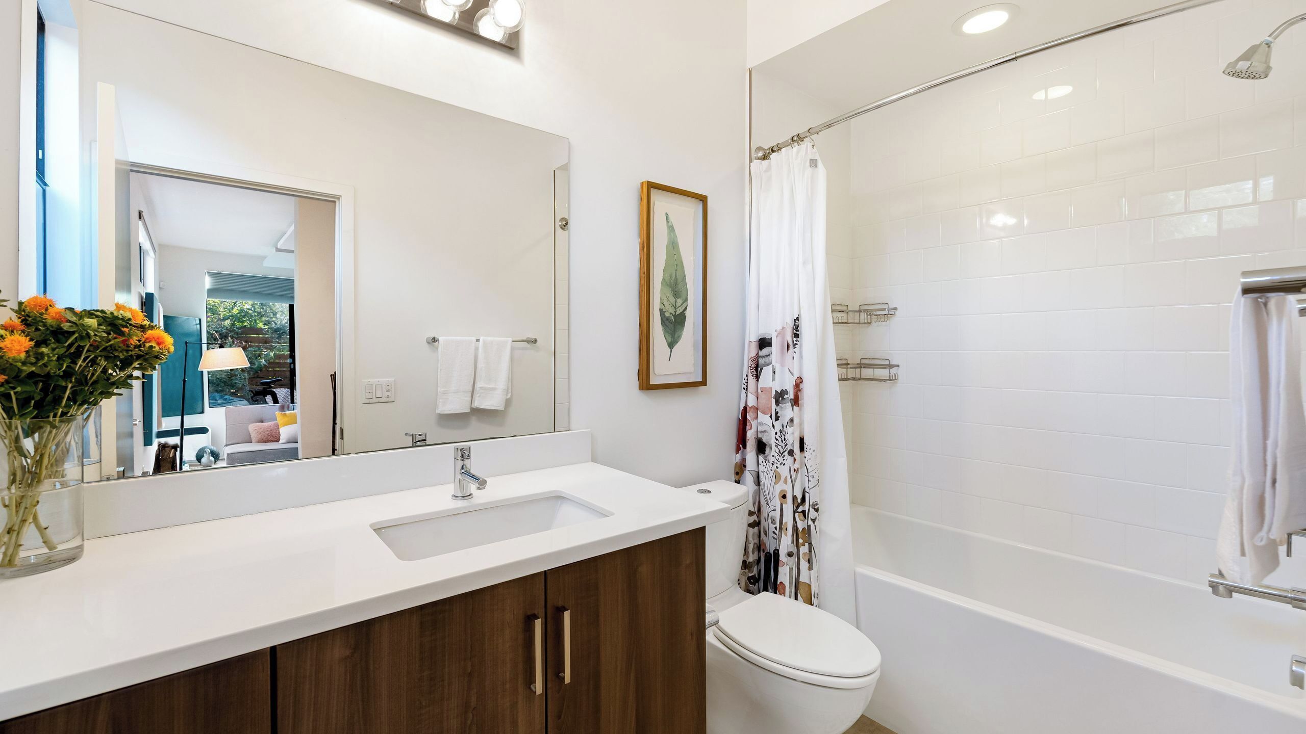 Et moderne badeværelse med en hvid vask, toilet og brusebad.