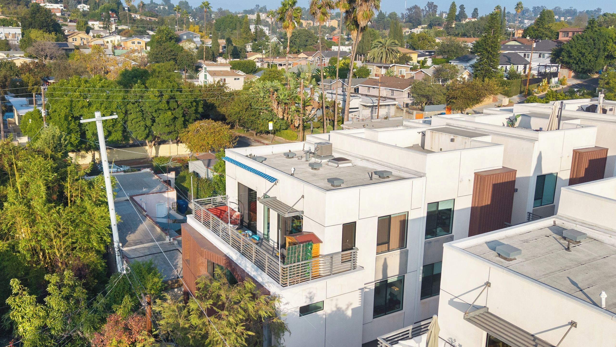 A modern building with multiple balconies, large windows, and a flat roof.