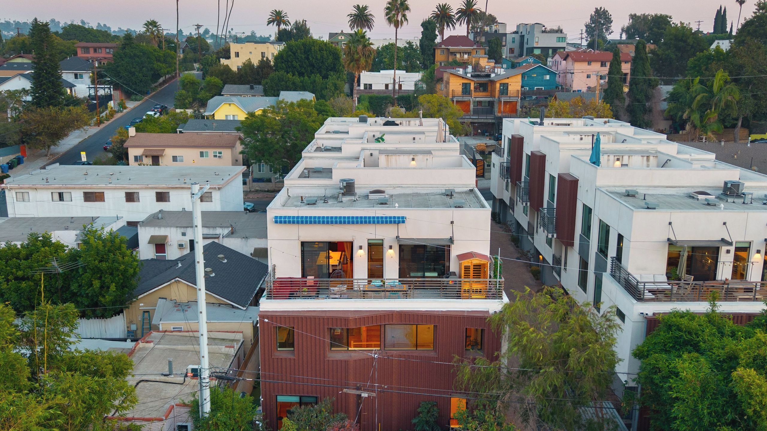 A residential area with modern buildings, including a house with a visible balcony and a building with solar panels.