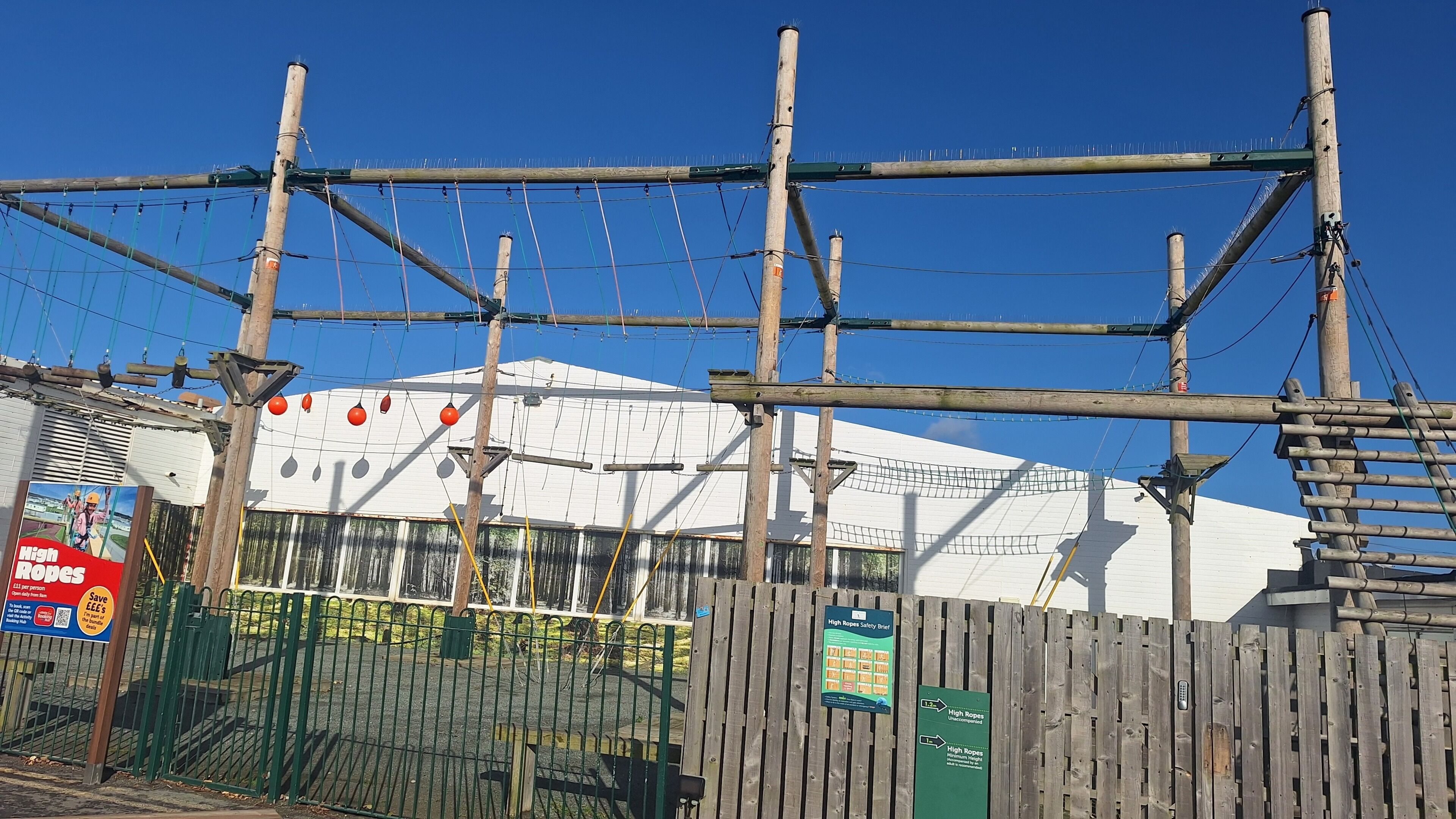 A high ropes course with wooden structures and safety nets.