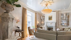 Ein geräumiges Wohnzimmer mit Kamin, einer Sofagarnitur und einem Essbereich mit Tisch und Stühlen.