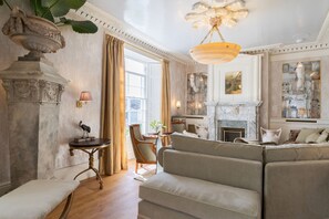 A spacious living room with a fireplace, a sofa set, and a dining area with a table and chairs. - Castle Lodge -  a house that sleeps 8 guests  in 4 bedrooms (Truro)