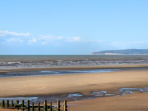 A wide beach with a fence in the foreground and a distant landmass. - Mkrj Premium - Parkdean Camber Sands - (Rye)