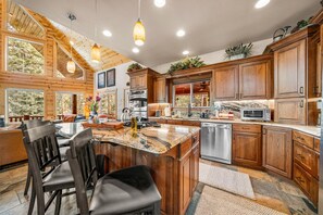 Una cocina moderna con armarios de madera, encimeras de granito y electrodomésticos de acero inoxidable.