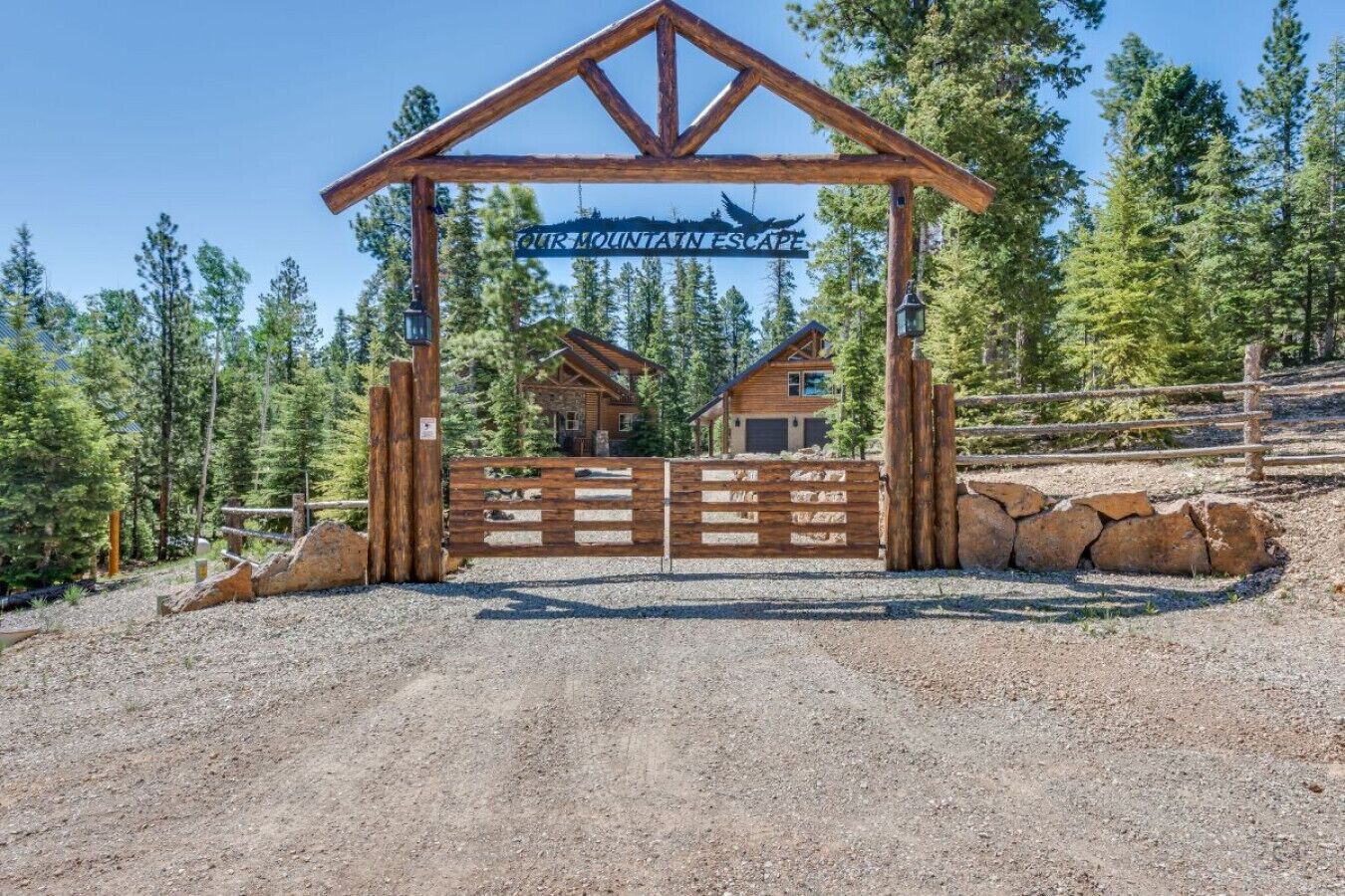 Une porte en bois sur laquelle on peut lire l’inscription « NOTRE RETRAITE EN MONTAGNE », avec un chalet de montagne en arrière-plan.