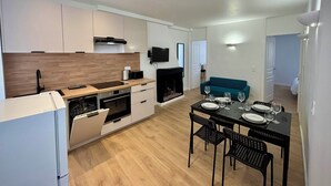 A modern kitchen with a dining area, a sofa, and a fireplace. - Casa Mare Lina Île rousse - T3 old town 1 min from the beach (L'Île-Rousse)