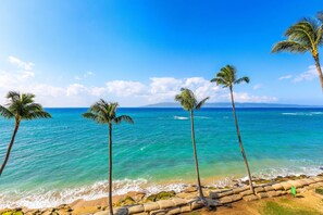 A beach with palm trees and clear blue water. - Valley Isle Resort #506 - Vacation West Maui (Lahaina)