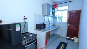 A compact kitchen with a stove, oven, and microwave.