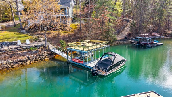 A docked boat with a covered area, a small bridge, and a building with a balcony.