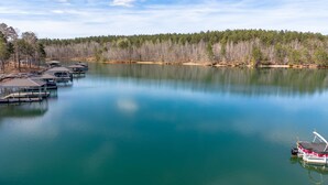 Um lago calmo com barcos atracados e margens arborizadas.
