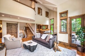 A spacious living area with a staircase, a dining area, and large windows. - Luxury West Vail Duplex - Multi-Level Living Areas (Vail)