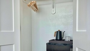 A compact kitchen with a black refrigerator, a wooden drying rack, and a small countertop with a kettle. - Bishop Arts 6BR/6BA townhouse, sleeps 12, parking (Dallas)