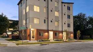 A multi-story hotel with a brick base and a light-colored upper section. - Bishop Arts 6BR/6BA townhouse, sleeps 12, parking (Dallas)