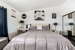 A bedroom with a large bed, two bedside tables, a mirror, and motivational wall art. - Perfect spacious 1-bedroom apartment in beautiful Hawthorne for your stay (Hawthorne)