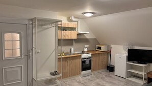 A compact kitchen with a microwave, oven, and a small refrigerator.