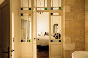 A room with a bed, a bedside table, and a hanging coat rack.