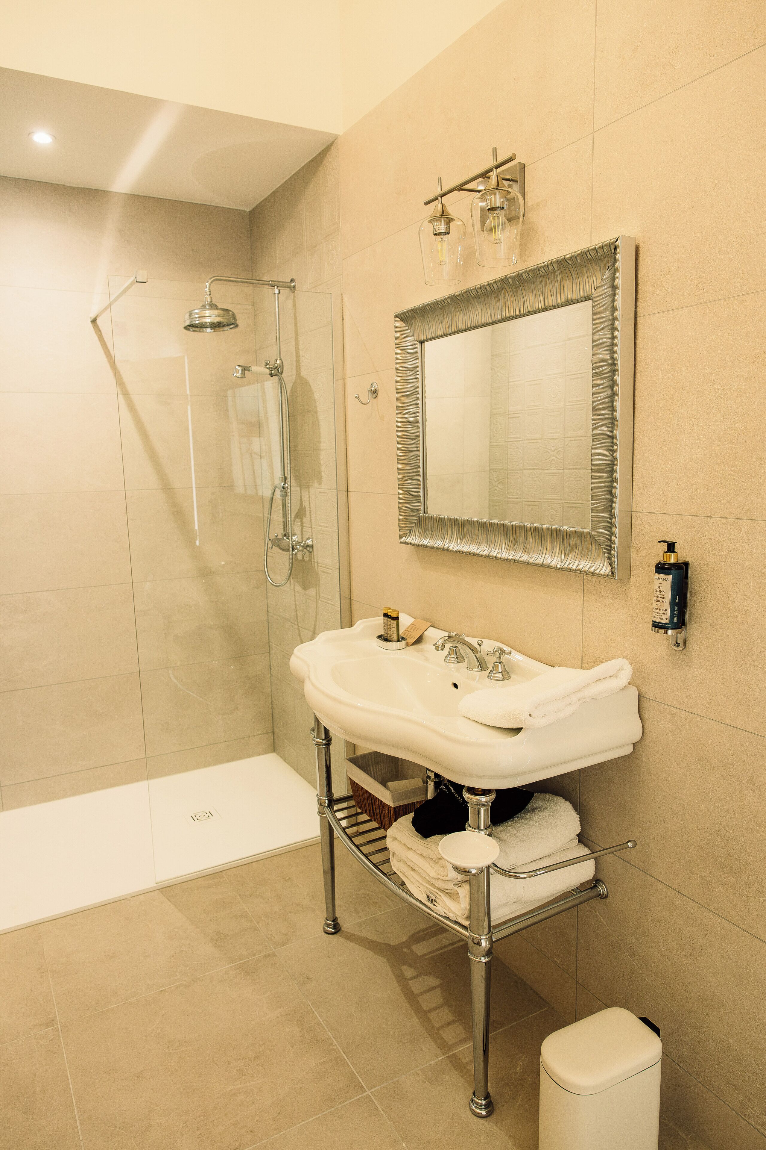 Un bagno con doccia vetrata, un mobile lavabo con specchio e un water.